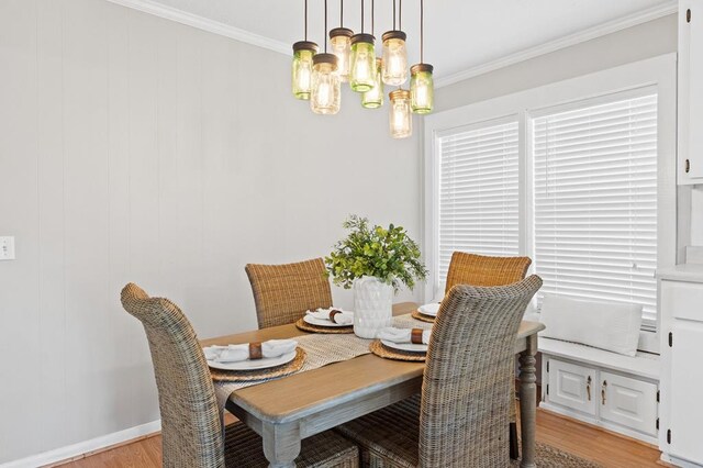 dining room featuring light hardwood / wood-style floors, an inviting chandelier, and crown molding