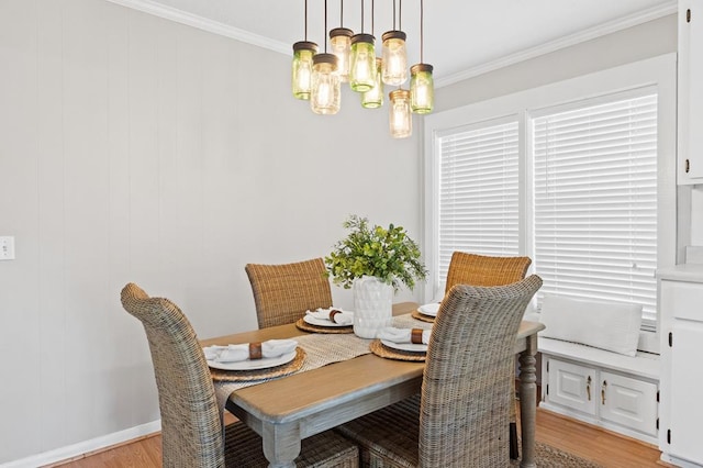 dining room featuring a notable chandelier, light wood-type flooring, baseboards, and crown molding