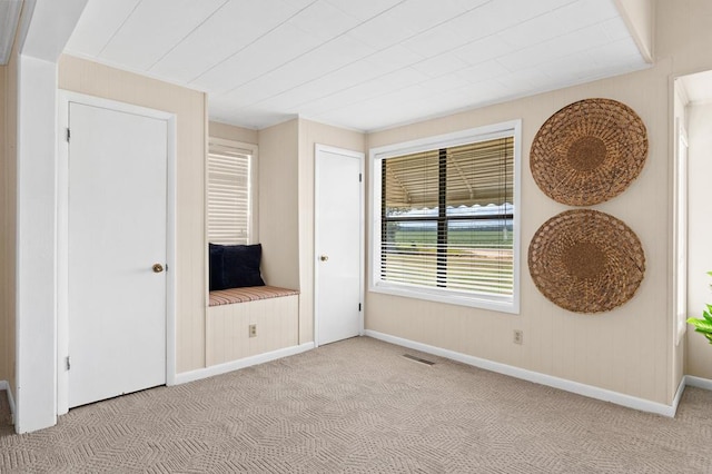 unfurnished bedroom with baseboards, visible vents, and light colored carpet