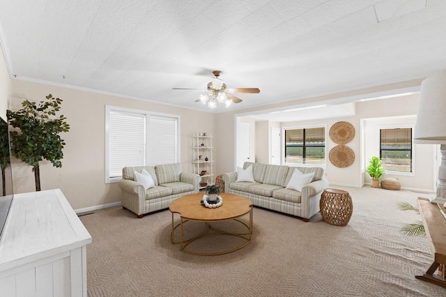 carpeted living room with crown molding, a ceiling fan, and baseboards