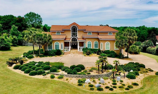 mediterranean / spanish-style home with a front lawn