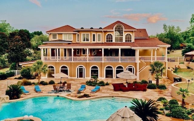 rear view of house with a patio and a balcony