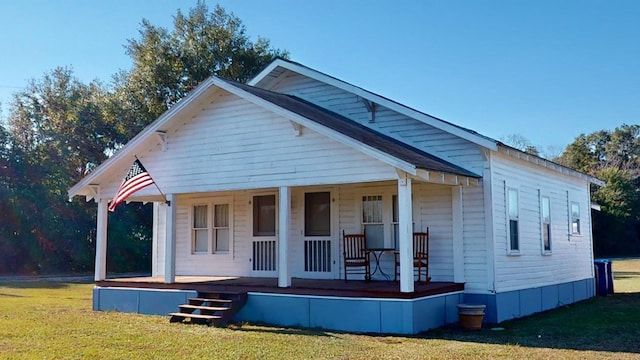 exterior space featuring covered porch and a yard