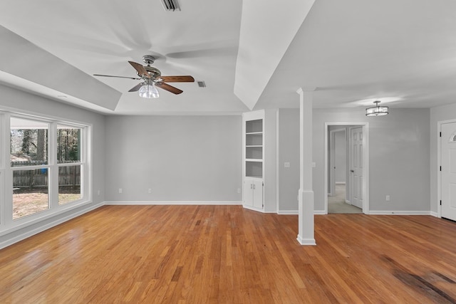 unfurnished room with a ceiling fan, visible vents, ornate columns, baseboards, and light wood finished floors