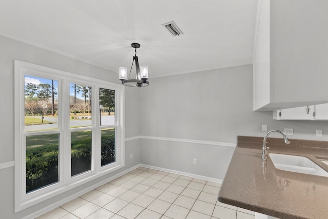 unfurnished dining area with ornamental molding, a notable chandelier, light tile patterned floors, and a sink