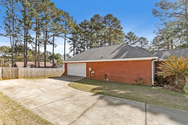 view of property exterior featuring fence, roof with shingles, an attached garage, concrete driveway, and brick siding