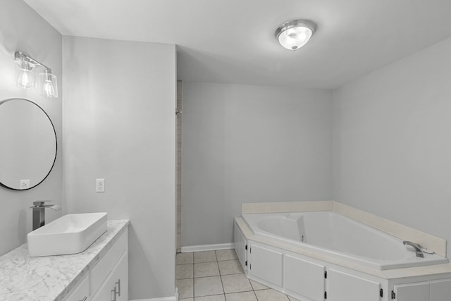 bathroom featuring tile patterned floors, baseboards, a bath, and vanity