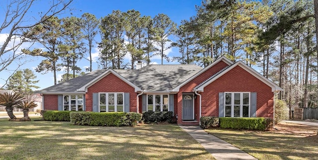 ranch-style home with a front lawn, brick siding, and a shingled roof