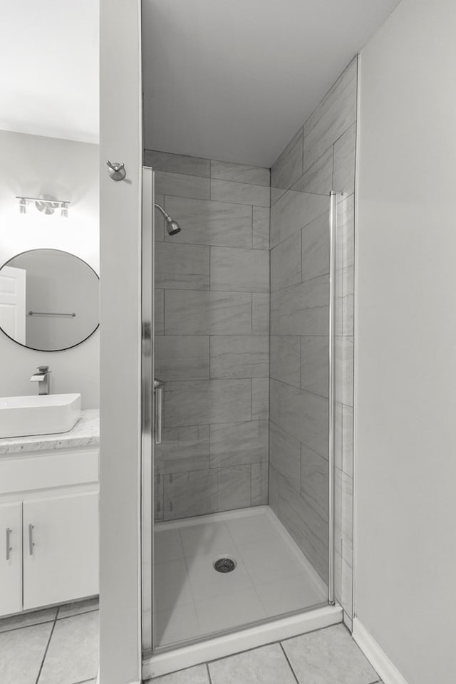 full bath featuring tile patterned floors, a shower stall, vanity, and baseboards