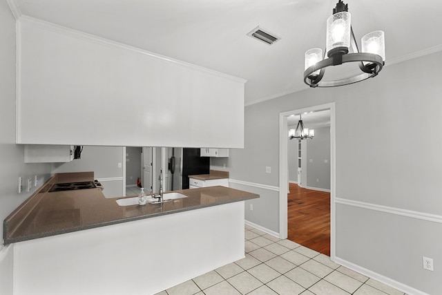 kitchen with light tile patterned flooring, visible vents, crown molding, and an inviting chandelier