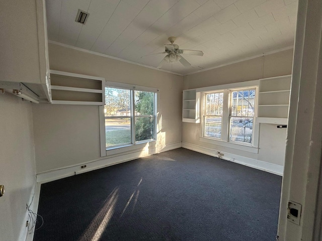 carpeted spare room with ceiling fan and crown molding