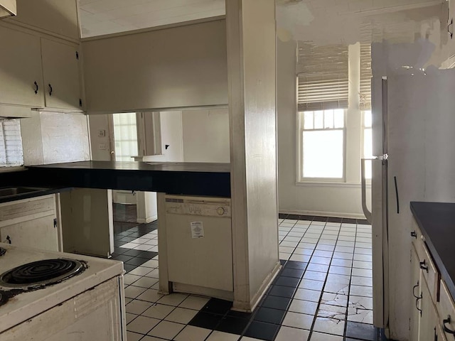 kitchen featuring light tile patterned flooring and white appliances