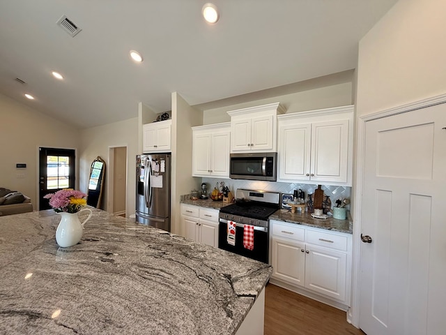103 Neenan Dr, Enterprise, AL 36330 - kitchen featuring appliances with stainless steel finishes, tasteful backsplash, white cabinets, light stone counters, and lofted ceiling