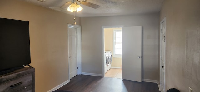 unfurnished bedroom with ceiling fan, baseboards, washer and clothes dryer, wood finished floors, and a textured ceiling