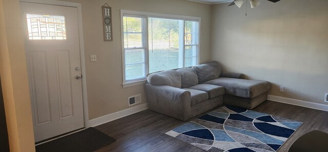 foyer entrance with dark wood-type flooring, baseboards, visible vents, and ceiling fan