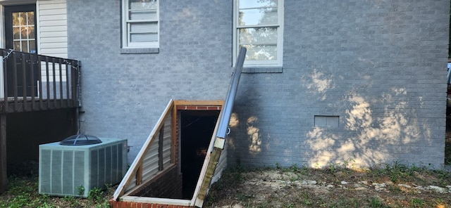 view of property exterior with cooling unit and brick siding