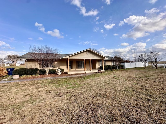 back of property with a lawn and a porch