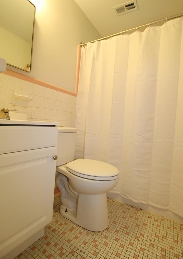 1125 Garden Ln, Dothan, AL 36301 - full bath featuring vanity, wainscoting, tile walls, and a shower with curtain