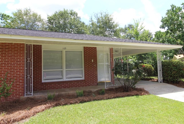 1125 Garden Ln, Dothan, AL 36301 - ranch-style house featuring brick siding, driveway, a front yard, and an attached carport