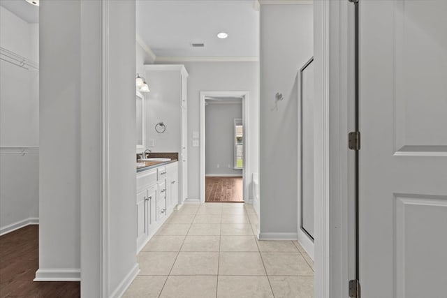 bathroom with hardwood / wood-style floors, vanity, a shower with door, and ornamental molding