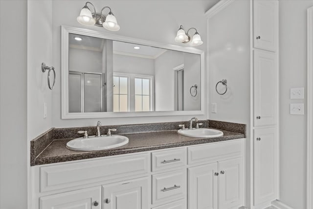 bathroom with ornamental molding, vanity, and a shower with shower door