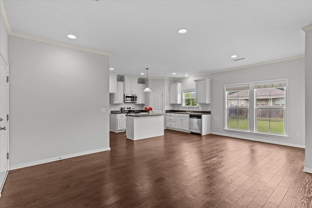 kitchen with appliances with stainless steel finishes, decorative light fixtures, white cabinetry, and dark wood-type flooring