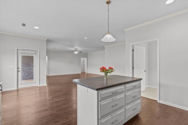 kitchen with crown molding, dark hardwood / wood-style flooring, and pendant lighting