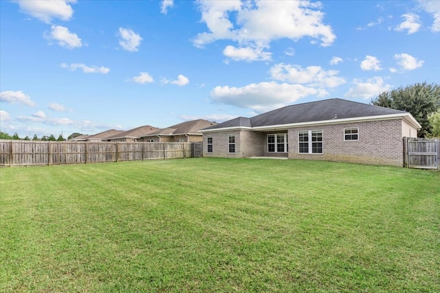 rear view of property with a lawn