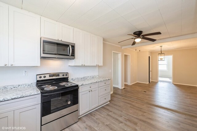 kitchen with crown molding, white cabinetry, and stainless steel appliances