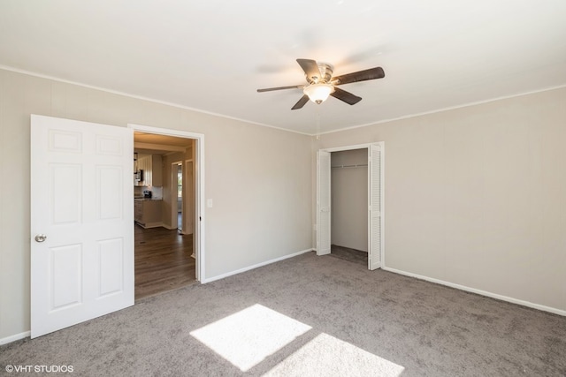 unfurnished bedroom featuring carpet flooring, ceiling fan, crown molding, and a closet