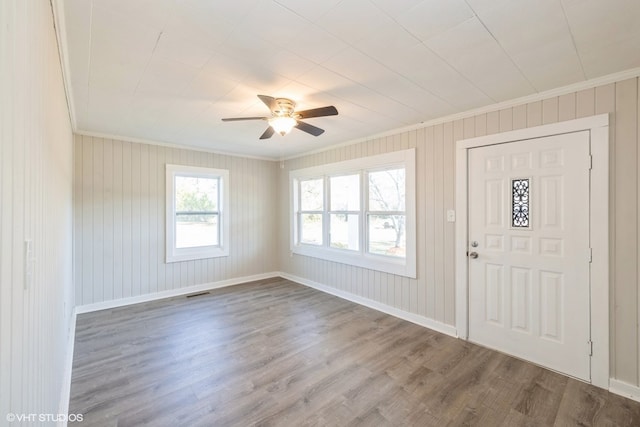 foyer entrance with ceiling fan, hardwood / wood-style floors, and crown molding