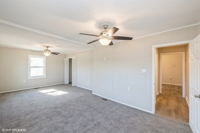 carpeted empty room with ceiling fan and ornamental molding