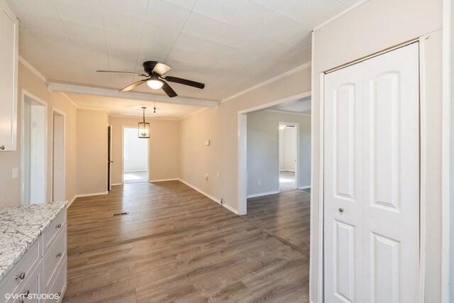 unfurnished living room with hardwood / wood-style flooring, ceiling fan, and ornamental molding