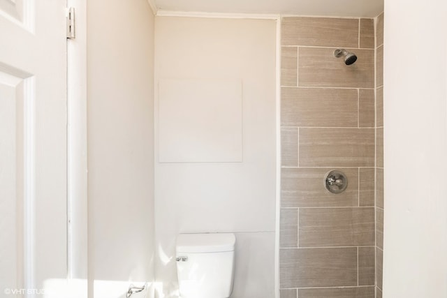 bathroom with tiled shower and toilet