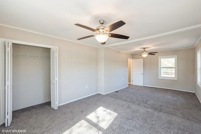 unfurnished bedroom featuring carpet floors, a closet, ceiling fan, and crown molding