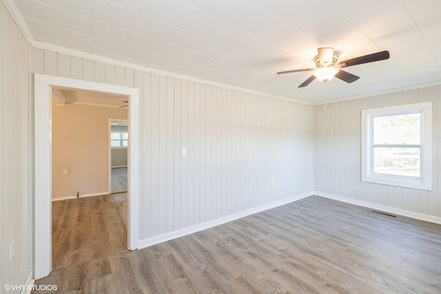 unfurnished room with wood-type flooring, crown molding, ceiling fan, and a healthy amount of sunlight