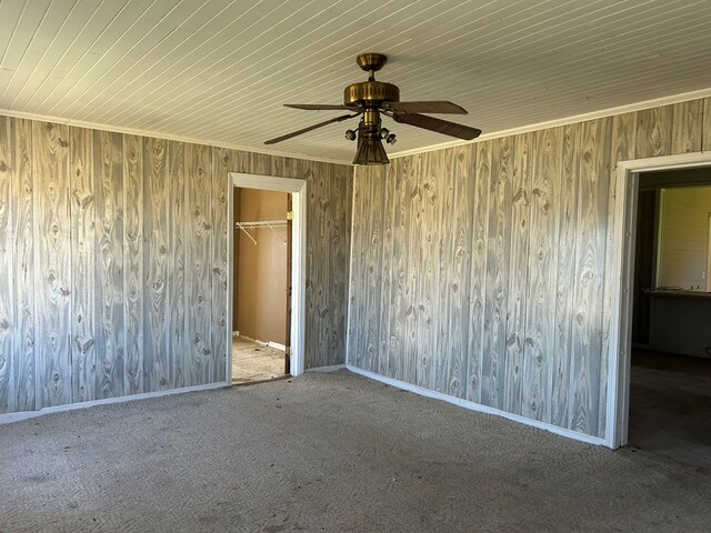 carpeted empty room featuring ceiling fan and baseboards