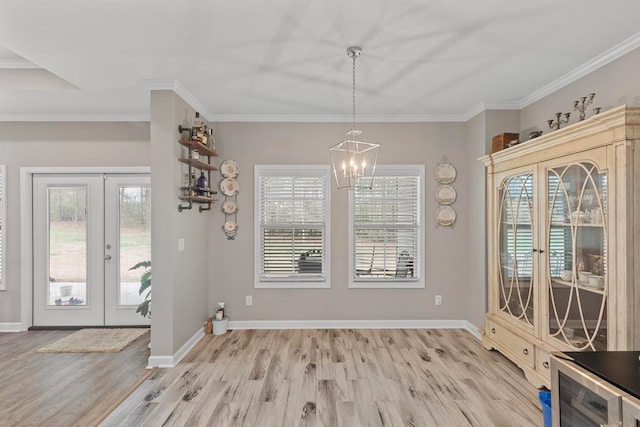 unfurnished dining area with ornamental molding, light hardwood / wood-style floors, and french doors