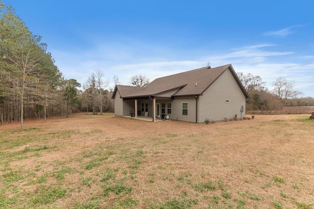 rear view of property featuring a yard and a patio area