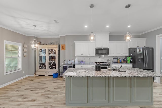 kitchen featuring black fridge, white cabinetry, and light stone counters