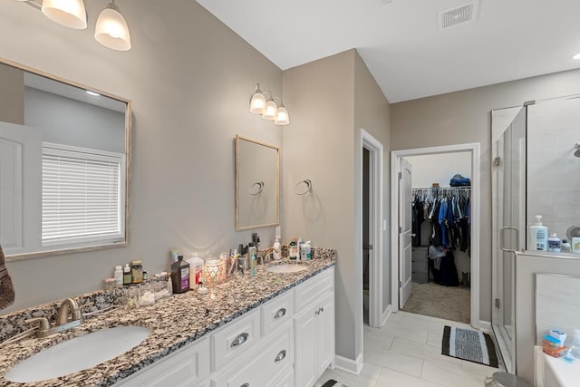 bathroom with tile patterned floors, vanity, and a shower with shower door