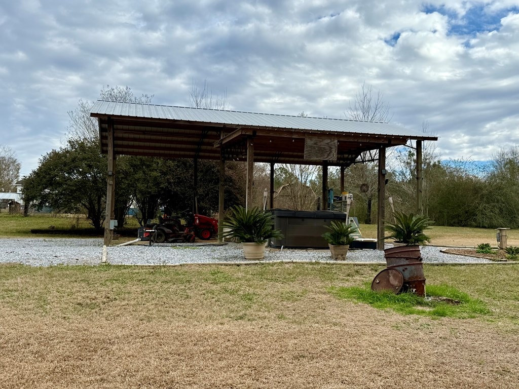 surrounding community with a hot tub and a lawn