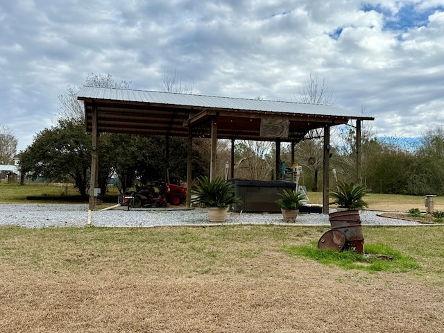 surrounding community with a hot tub and a lawn