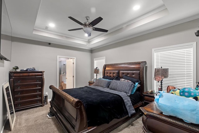 bedroom featuring multiple windows, a tray ceiling, light colored carpet, and crown molding