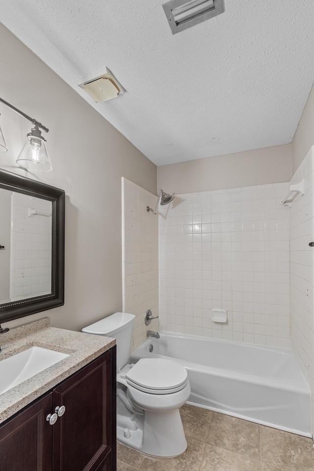 full bathroom with vanity, tiled shower / bath, a textured ceiling, and toilet