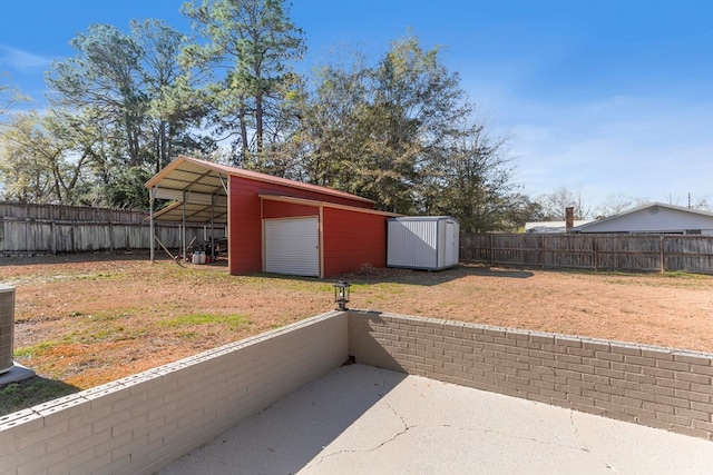 view of yard with a carport, a patio, and a shed