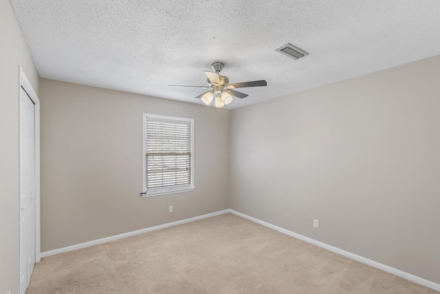 carpeted empty room featuring a textured ceiling and ceiling fan