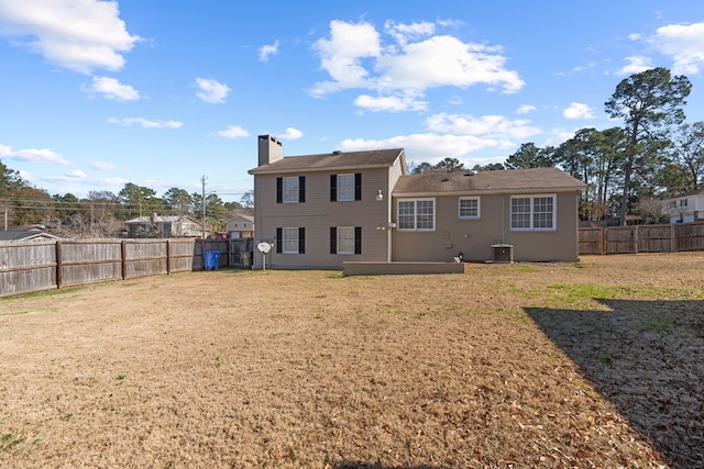 back of property with cooling unit and a yard