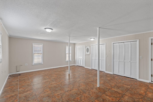 interior space featuring crown molding, a textured ceiling, and wood walls