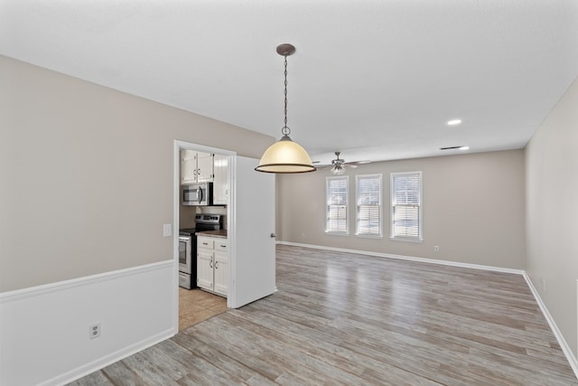 interior space with ceiling fan and light hardwood / wood-style flooring